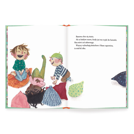 Chłopiec o ciemnoblond włosach siedzi na poduszce i głośno się śmieje. Obok niego kuca na czworaka chłopiec w zielonej czapce, bluzce w biało-niebieskie pasy i brązowych spodniach. Między nimi wśr&oacute;d poduszek leży czarna dziewczynka w r&oacute;żowej bluzce i oliwkowych rajstopach i zanosi się śmiechem, wskazując palcem na pierwszego chłopca.